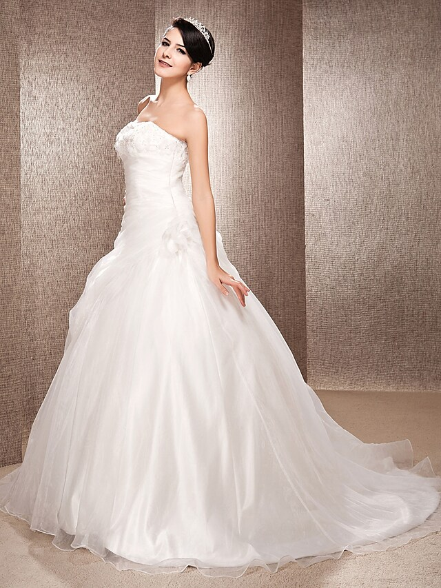 Close-up of the strapless bodice and delicate organza fabric of the bridal dress.