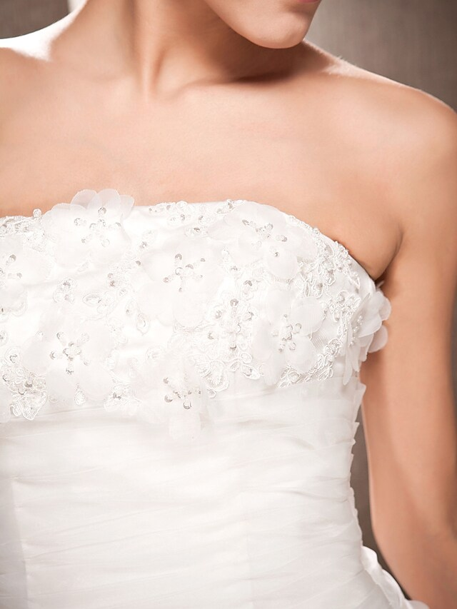 Bridal gown from a slightly elevated angle, showing the full design and drape.