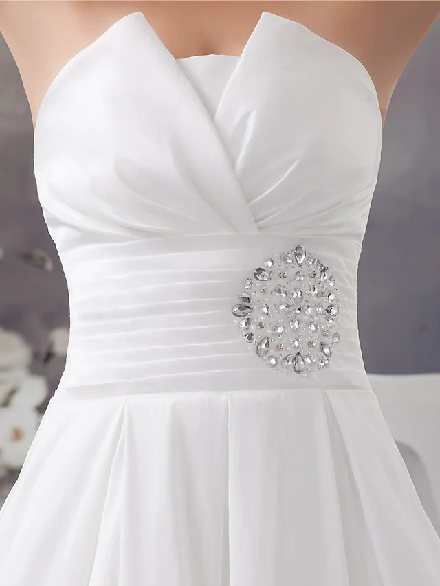 Detailed view of the satin fabric and draping on the wedding dress.