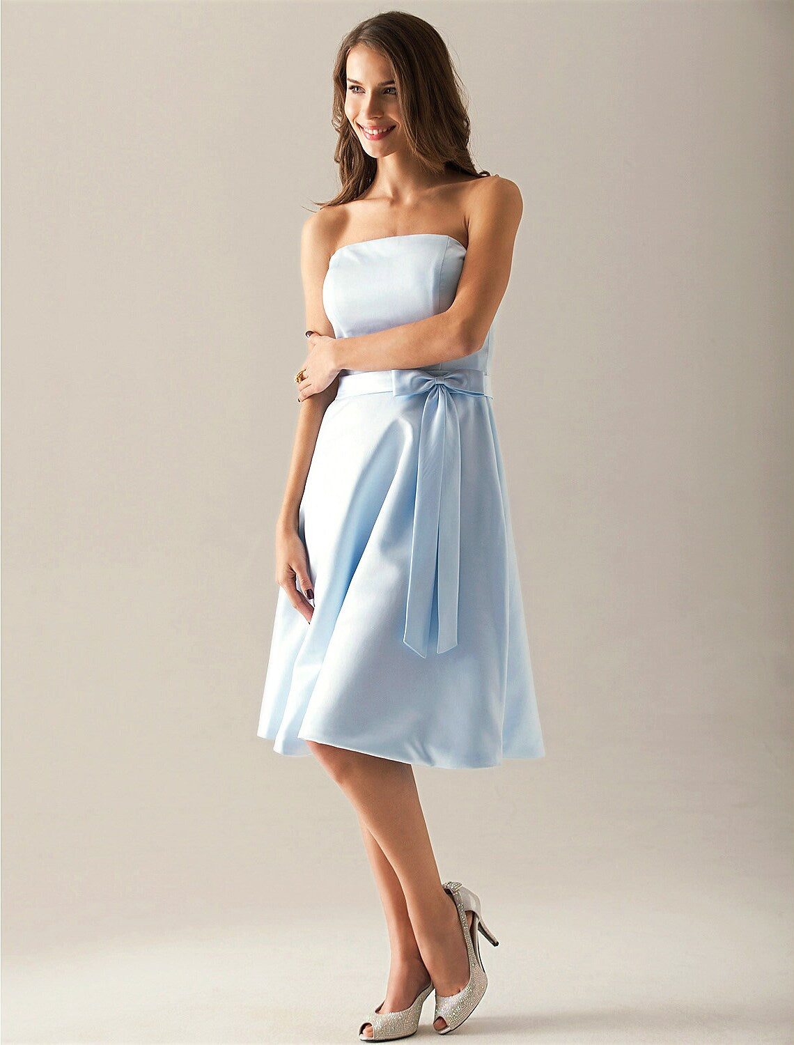 Model wearing an elegant A-line strapless satin bridesmaid dress with a sash, front view.