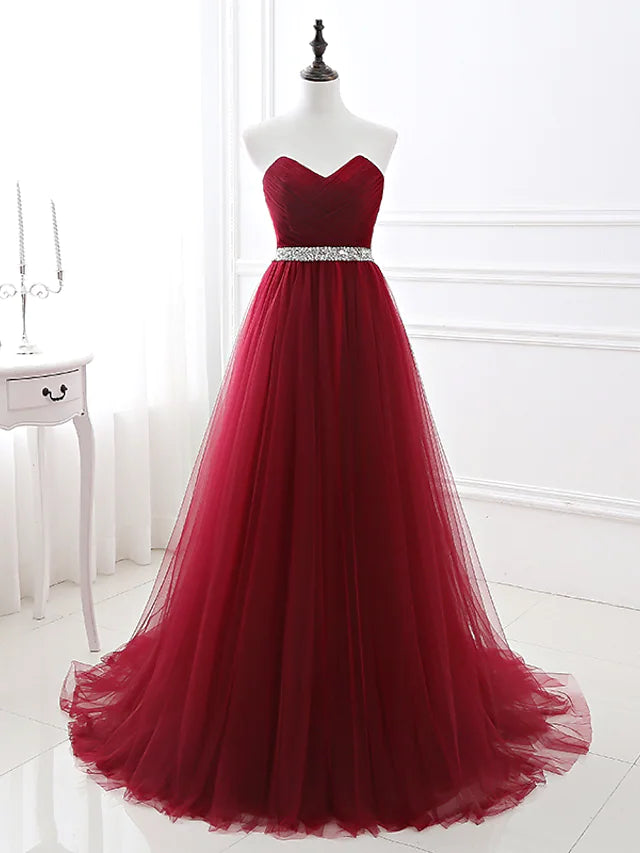 Full view of an elegant A-line strapless satin dress with a chapel train and crystal embellishments.