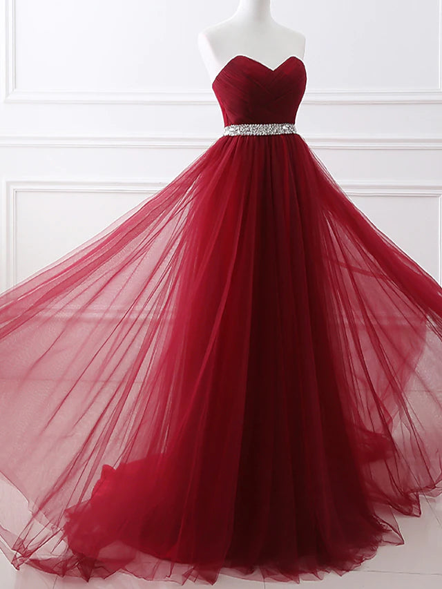 Back view of the elegant strapless satin gown with a flowing chapel train.