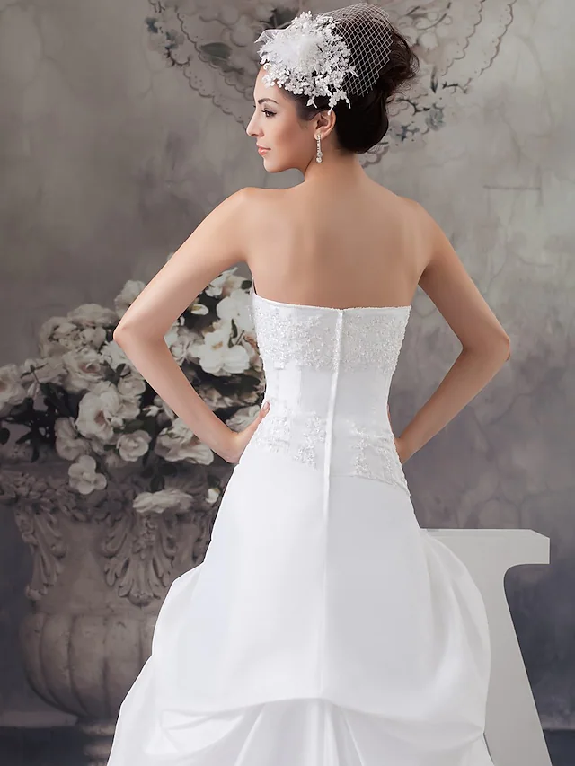 Full length view of strapless satin wedding dress.
