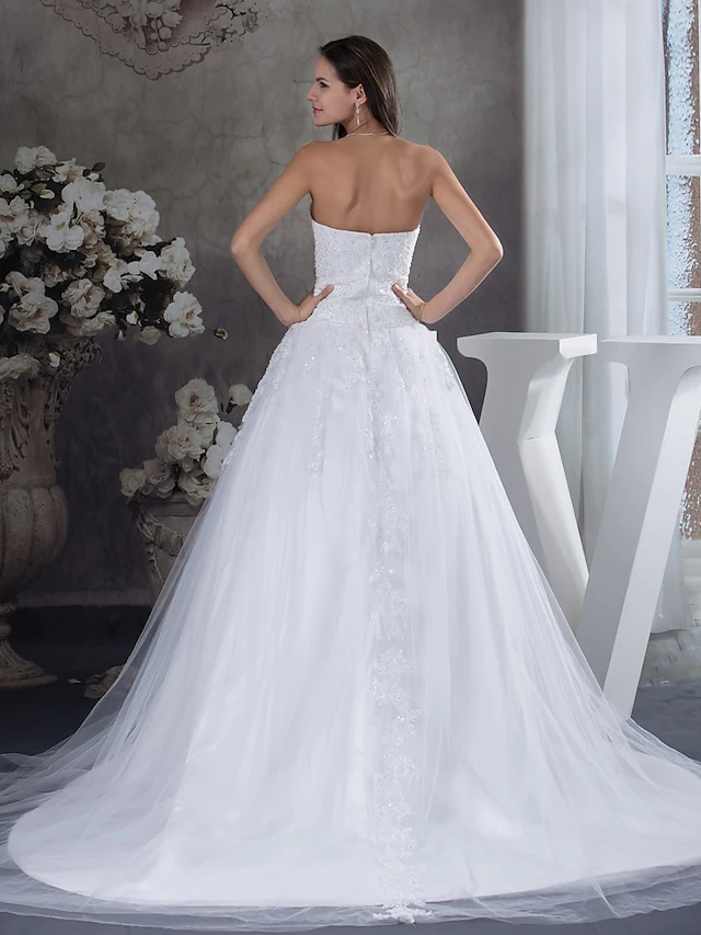 Close-up of the lace and beading details on a strapless wedding dress.