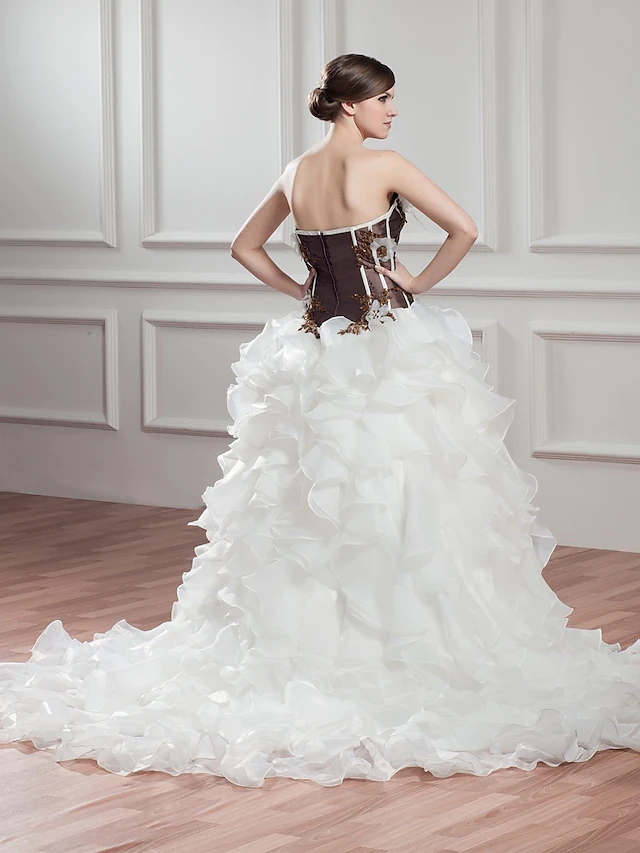 Back view of the strapless wedding dress with intricate beading and long train.