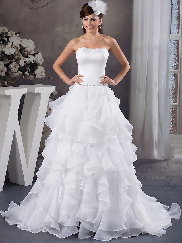Elegant A-line strapless wedding dress with beading and cascading ruffles.