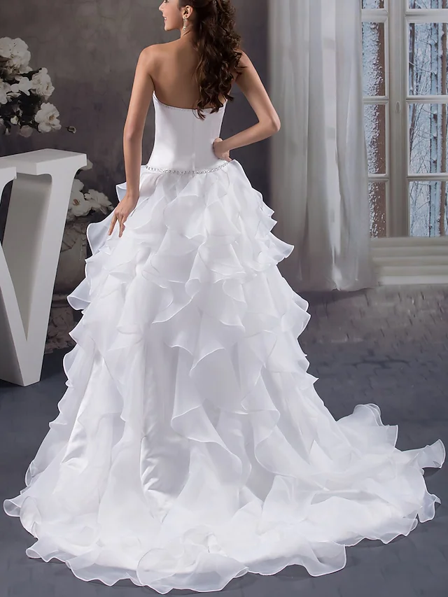 Close-up of beading and organza ruffles on strapless wedding dress.