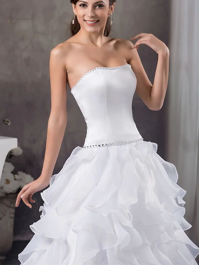 Side view of A-line bridal gown with flowing satin and organza.