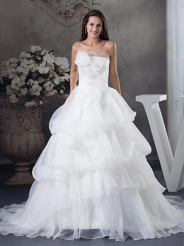 Elegant A-Line strapless wedding dress with chapel train and pick-up skirt.