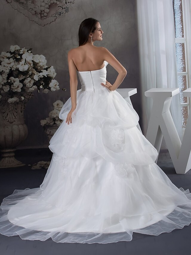 Side view of elegant strapless bridal gown with pick-up skirt.