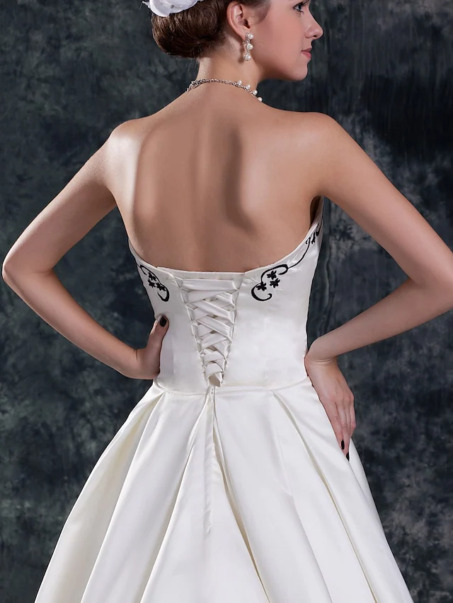 Full length view of the elegant strapless organza and satin wedding dress.