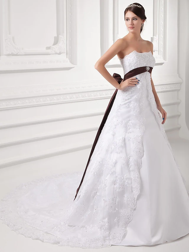 Close-up of intricate lace and beading details on the strapless wedding gown.