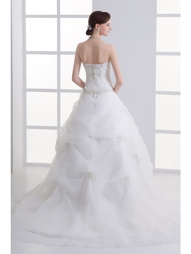 Close-up of strapless A-Line wedding dress bodice with intricate beading.