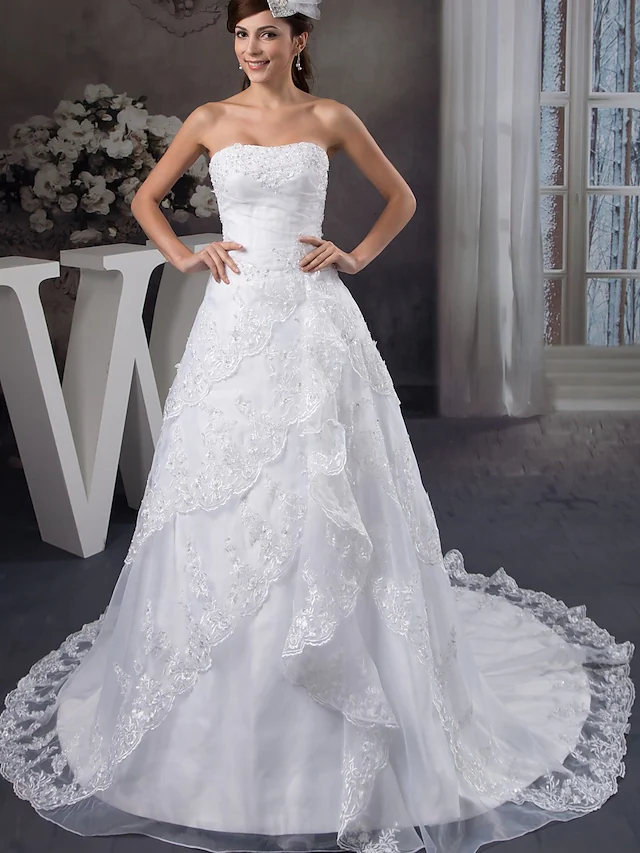 Elegant A-Line strapless wedding gown with beading and appliques.