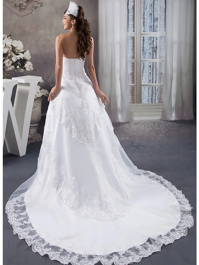 Close-up of intricate beading and lace appliques on a wedding dress.