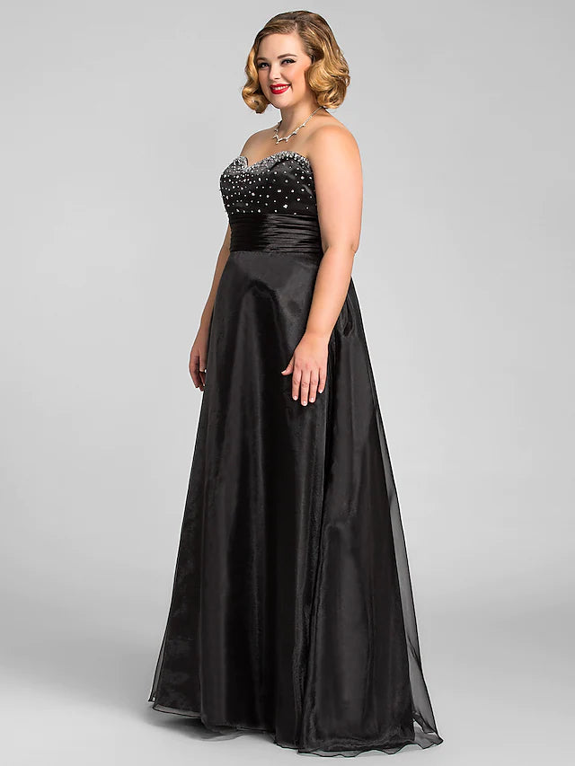 Side view of a floor-length black organza gown featuring delicate beading.