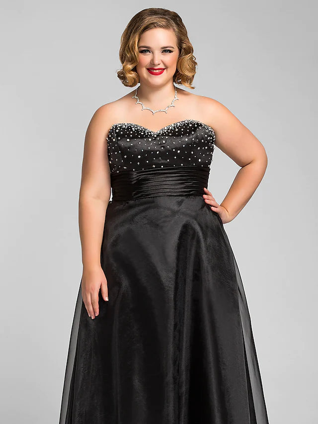Close-up of the ruched detailing and beading on the sweetheart neckline of the black dress.