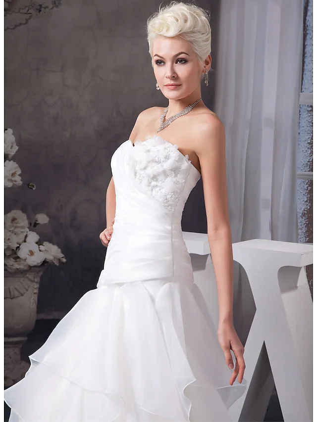 Close-up of ruched appliques and lace on a wedding dress.