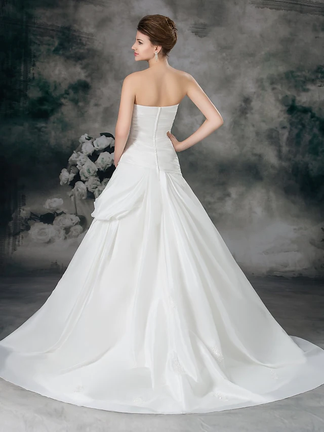 Full length view of strapless A-line bridal gown with flowing skirt.