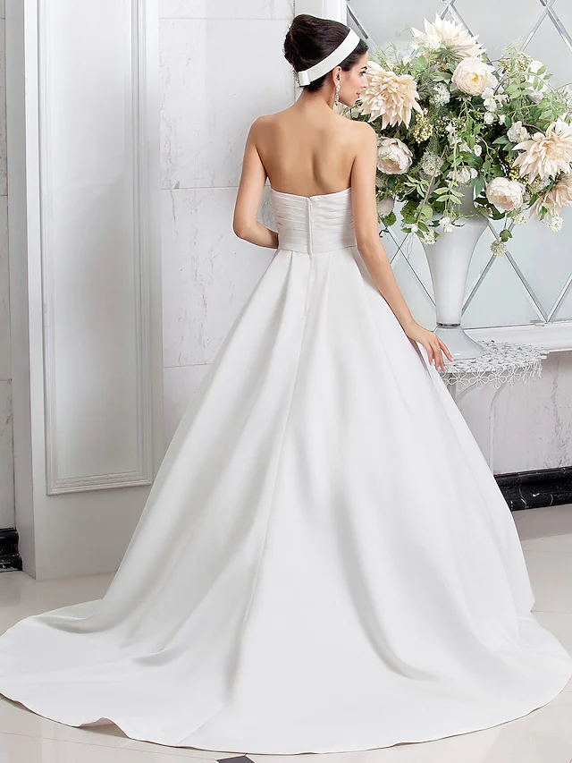 Side profile of the elegant A-Line wedding gown with ruched details.