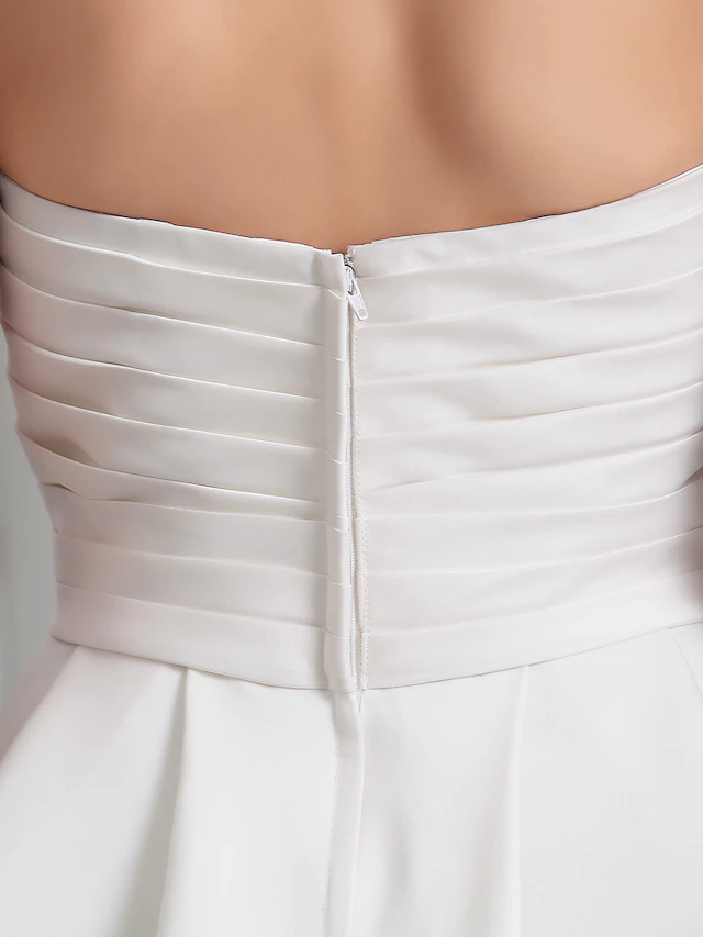 Elegant pose in the sleeveless satin wedding dress with a subtle train.