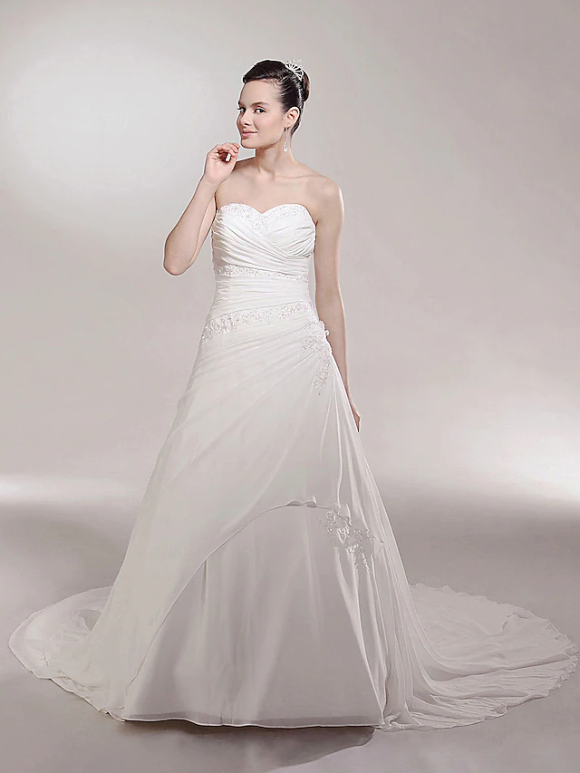 Back view of strapless chiffon wedding dress with long train.