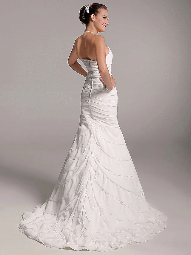 Side view of elegant A-Line wedding gown with flowing train.