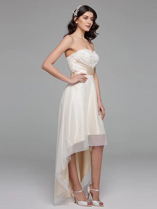 Close-up of delicate floral lace and ribbon beading on wedding dress.