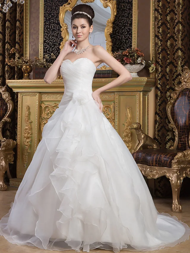 Elegant A-line sweetheart wedding dress with ruched bodice and cascading ruffles.