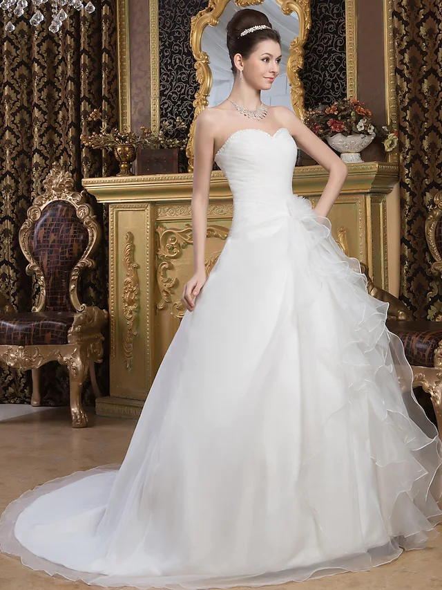Back view of a white A-line wedding gown featuring a long court train.