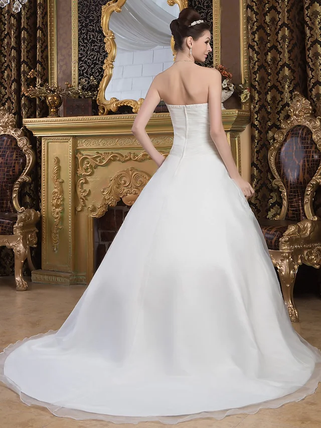 Close-up of the delicate ruched organza and smooth satin fabric on the wedding dress.