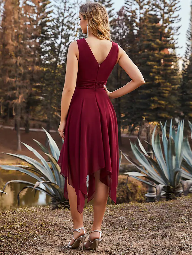Woman wearing a ruched A-line V-neck chiffon bridesmaid dress, side view.