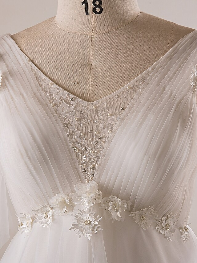 Detail of V-neckline and half sleeve on wedding gown.