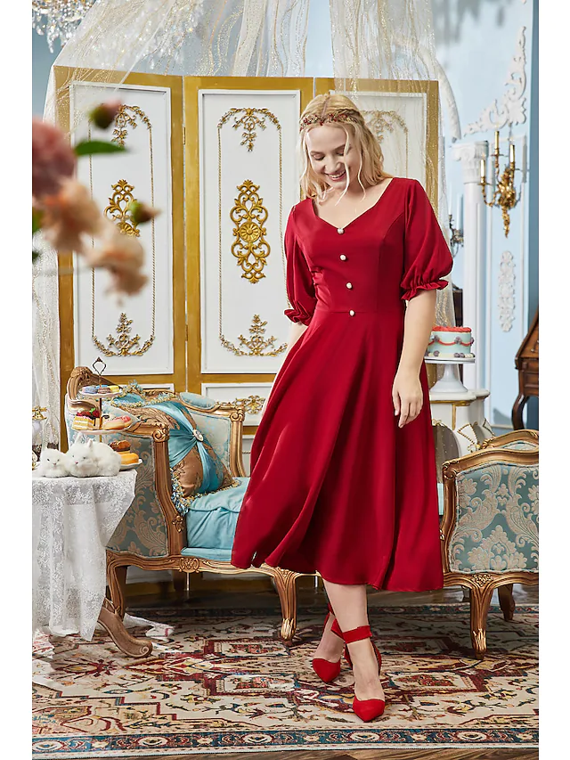 Back view of a tea-length plus size dress with pleats.