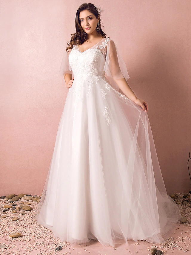 Side view of an A-Line V-Neck half sleeve wedding dress, showcasing the appliques and train.