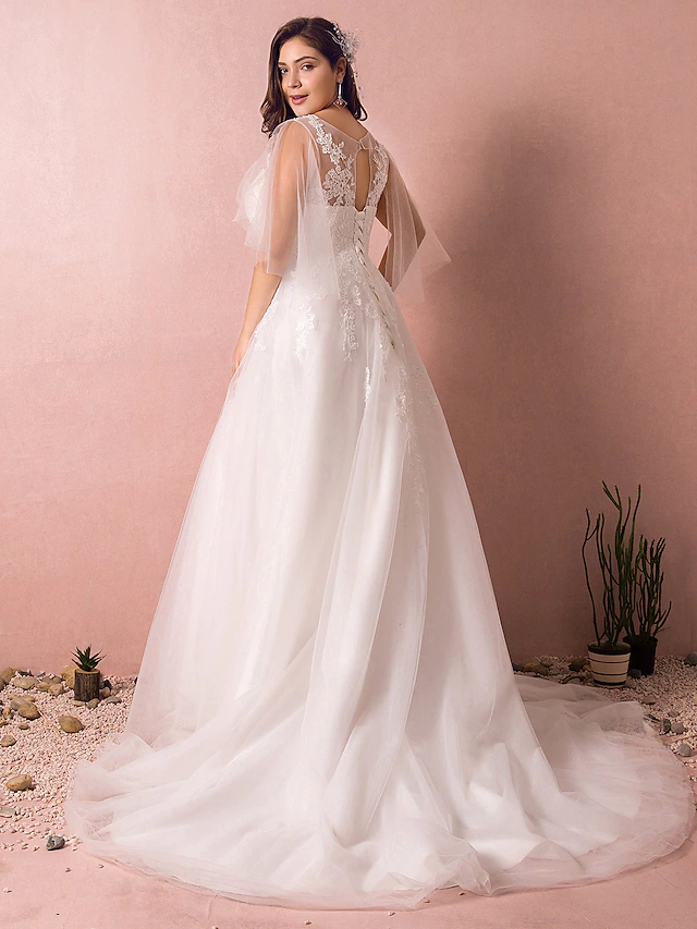 Close-up of the V-neckline and half sleeves on the wedding dress with appliques.
