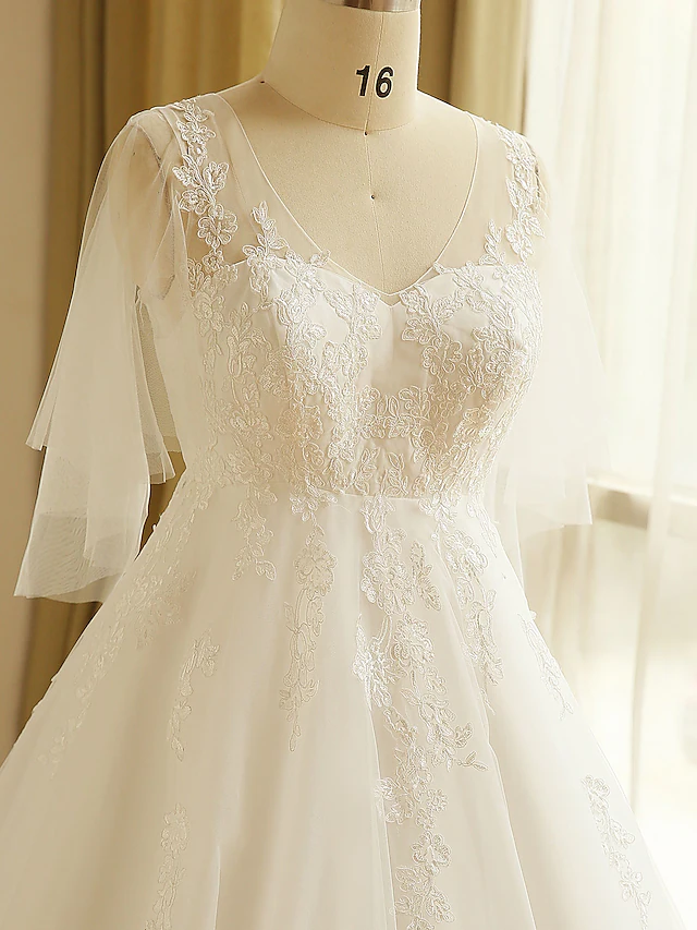 Close-up of the fabric and applique details on the A-Line wedding dress.