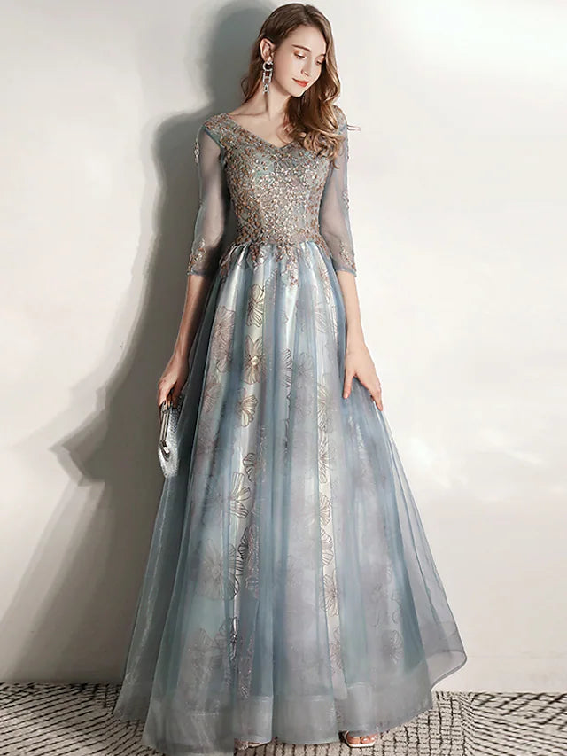 Full view of a light-colored A-Line formal gown with intricate pleats.