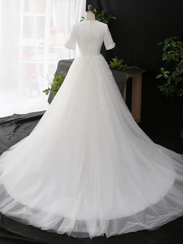 Side view of the A-line wedding dress, showing the court train and appliques.