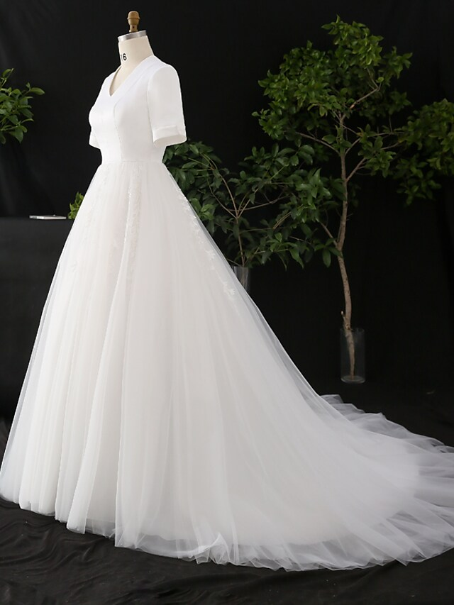 Close-up of the V-neckline and half sleeves of the wedding gown.