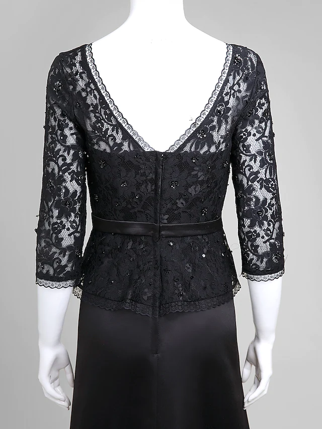 Detail of the V-neckline and intricate lace embellishments on the elegant dress.