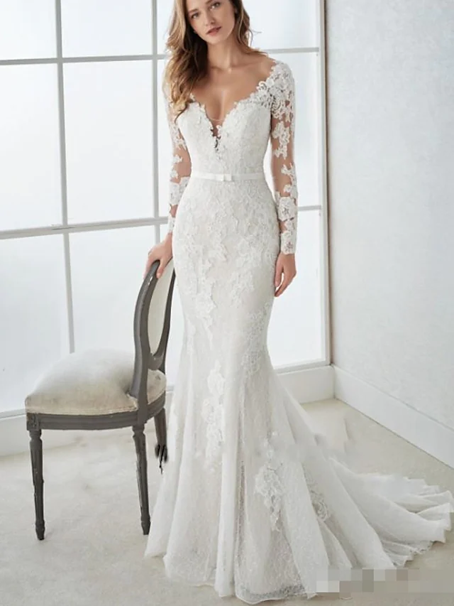 Romantic bridal gown featuring a V-neckline, intricate lace details, and flowing tulle skirt.