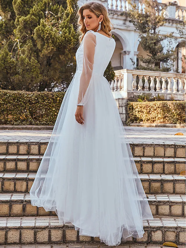 Front view of an elegant white A-line V-neck wedding dress with lace and tulle.