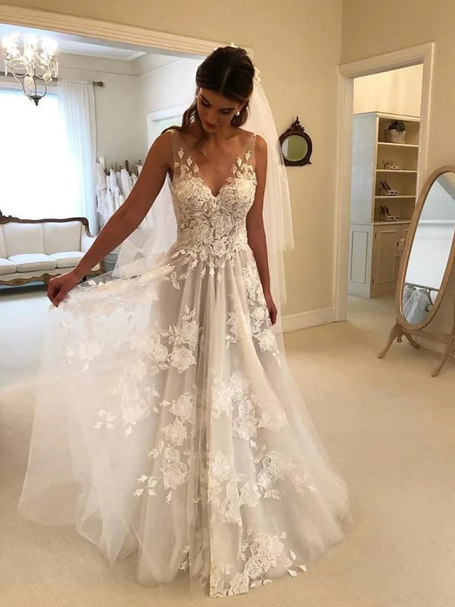 Model wearing an elegant A-line V-neck lace wedding dress with a court train.