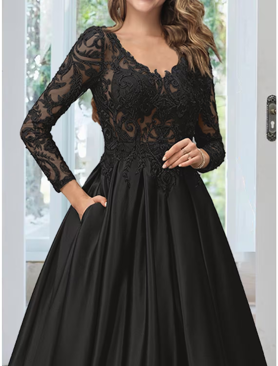 Close-up of the delicate lace and applique details on the black evening gown.