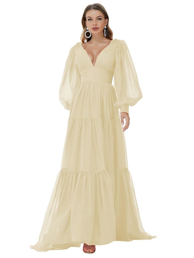 Full length view of a woman in an A-line V-neck long sleeve ruched chiffon evening gown.