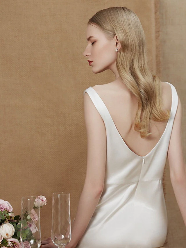 Full length view of a sleeveless A-Line V-Neck bridal gown.
