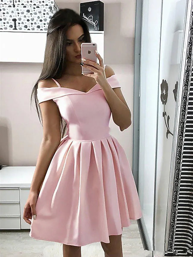 Model wearing an A-line V-neck sleeveless knee-length cocktail dress with pleats.