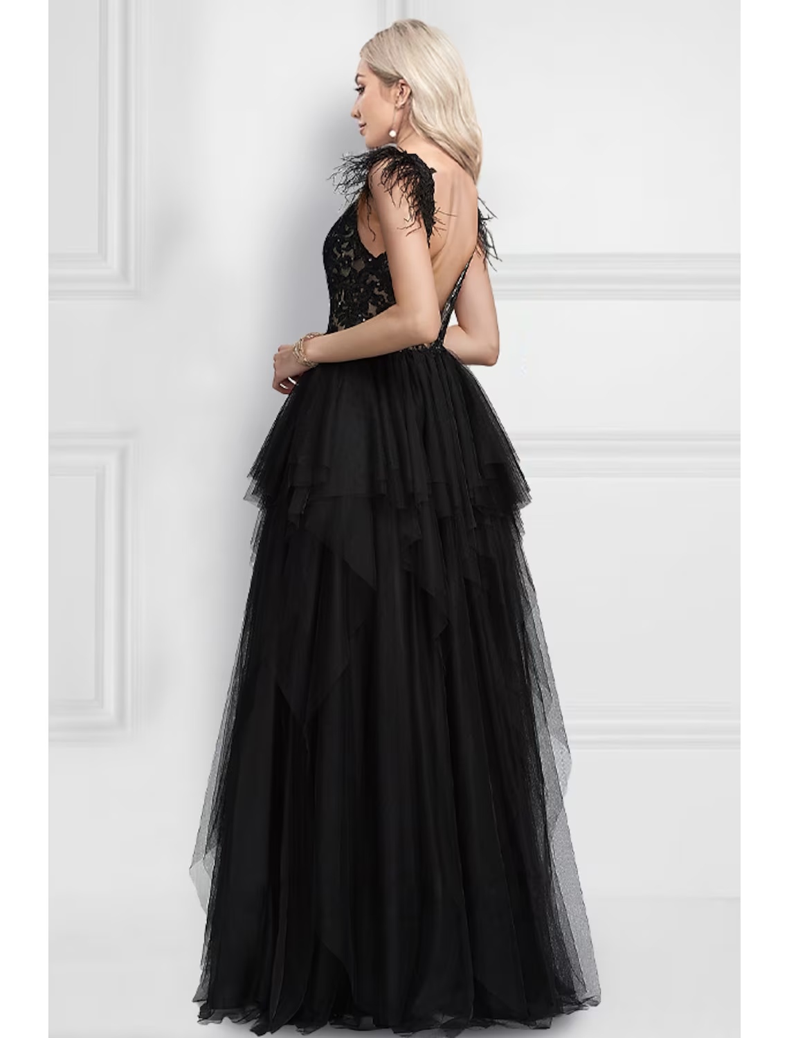 Side view of a black sleeveless A-Line gown with feather details on the bodice.