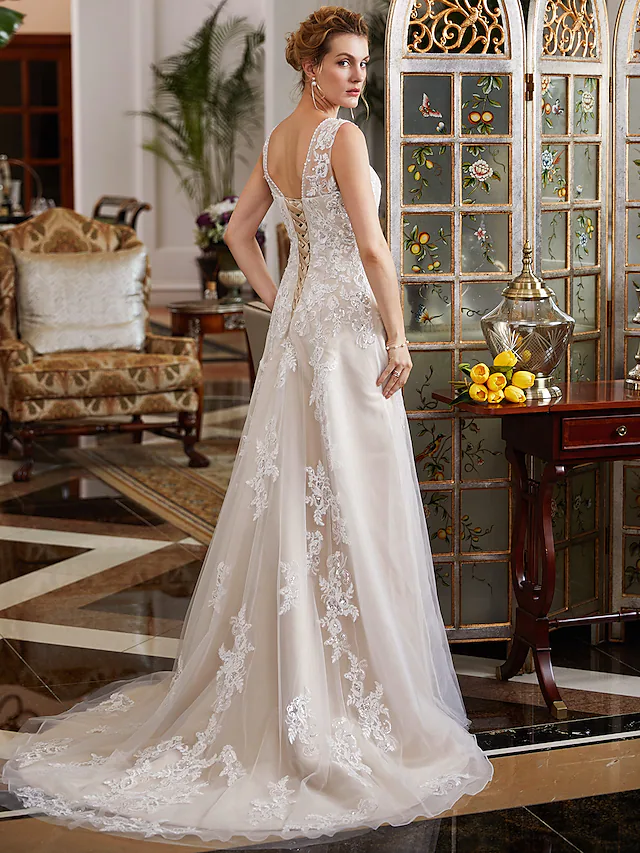 Close-up of the V-neckline and bodice of the wedding dress with intricate lace and beading details.